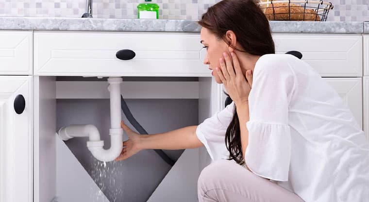 Homeowner practicing simple plumbing maintenance habits to prevent issues